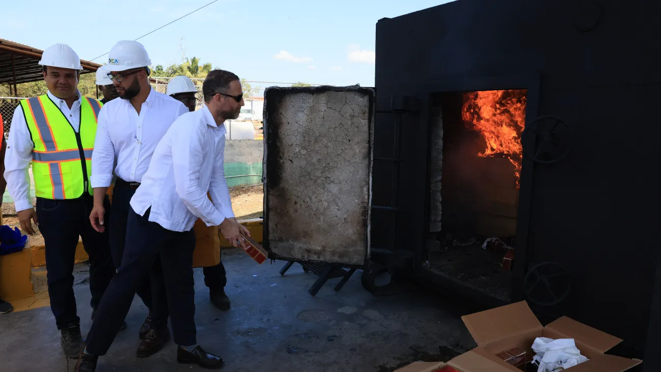 Foto 2 Los subdirectores de la DGA, Daniel Peña y Francis Almonte, proceden a la incineración de los cigarrillos incautados.