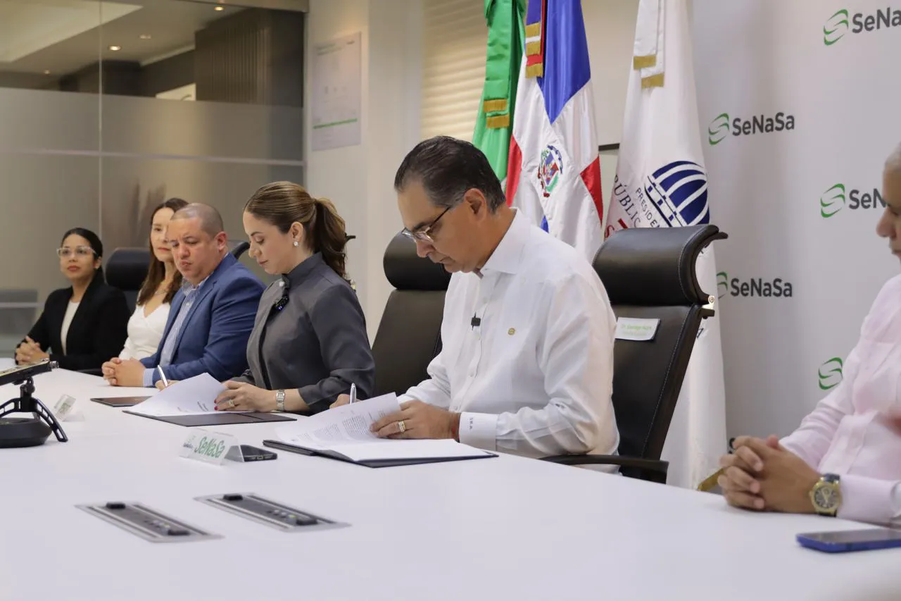 Gloria Reyes, directora general de Supérate junto al doctor Santiago Hazim, director ejecutivo de SeNaSa, rubricando sus firmas tras realzar un acuerdo para brindar seguro de salud para los más vulnerables de la nación